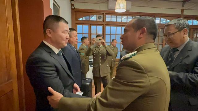 Un oficial pone la piocha a un nuevo integrante