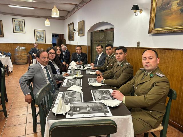 Integrantes y carabineros sentados a la mesa