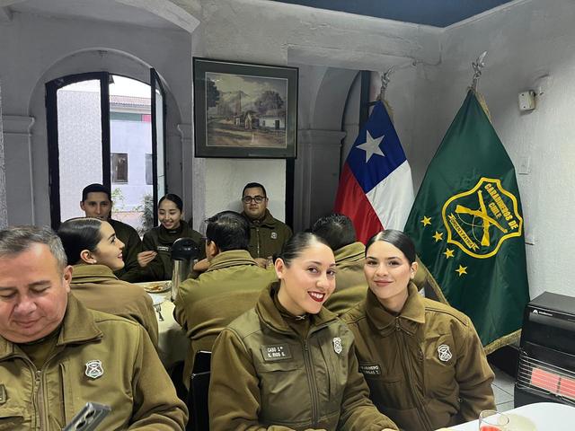 Carabineros a la mesa, con la bandera de Chile y el estandarte al fondo
