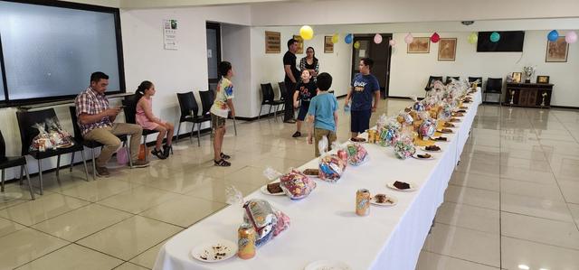 Vista del salón con las familias y la mesa de regalos